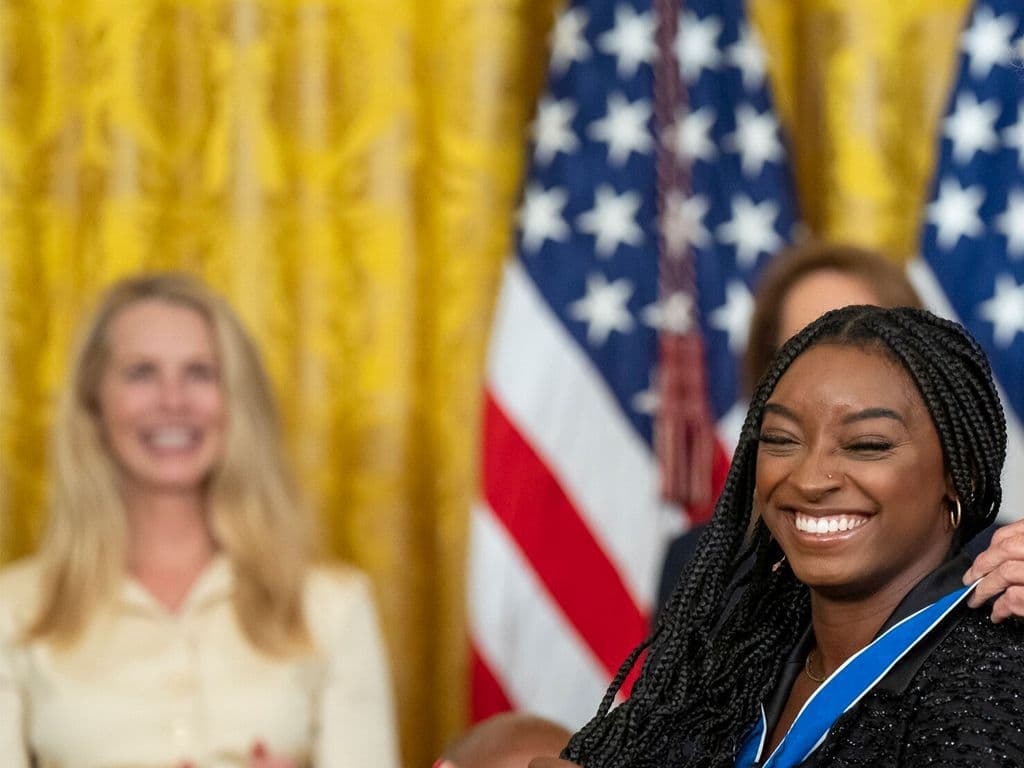 Nina Derwael mag met voorsprong onze beste Belgische turnster ooit zijn. In haar generatie moet ze het allround toch onderdoen voor deze Amerikaanse. Met reeds 19 medailles op Olympische Spelen en WK’s is ze de meest gelauwerde Amerikaanse gymnaste aller tijden. Op zesjarige leeftijd kwam ze tijdens een uitje bij de dagverzorging in aanraking met gymnastiek, waarop één van de trainers haar aanraadde daarmee door te gaan… Graag haar naam.