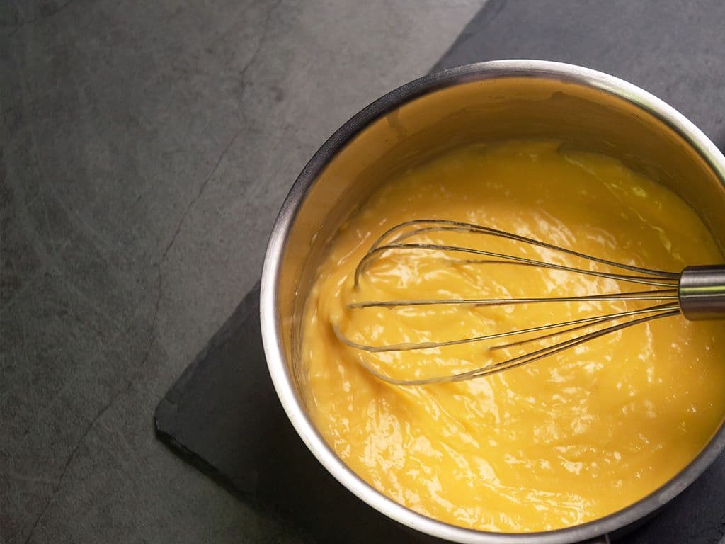Hoe heet de kooktechniek waarbij aan een warme vloeistof klontjes boter worden toegevoegd en met een garde geroerd, om zo de saus te binden en een vollere smaak te geven?