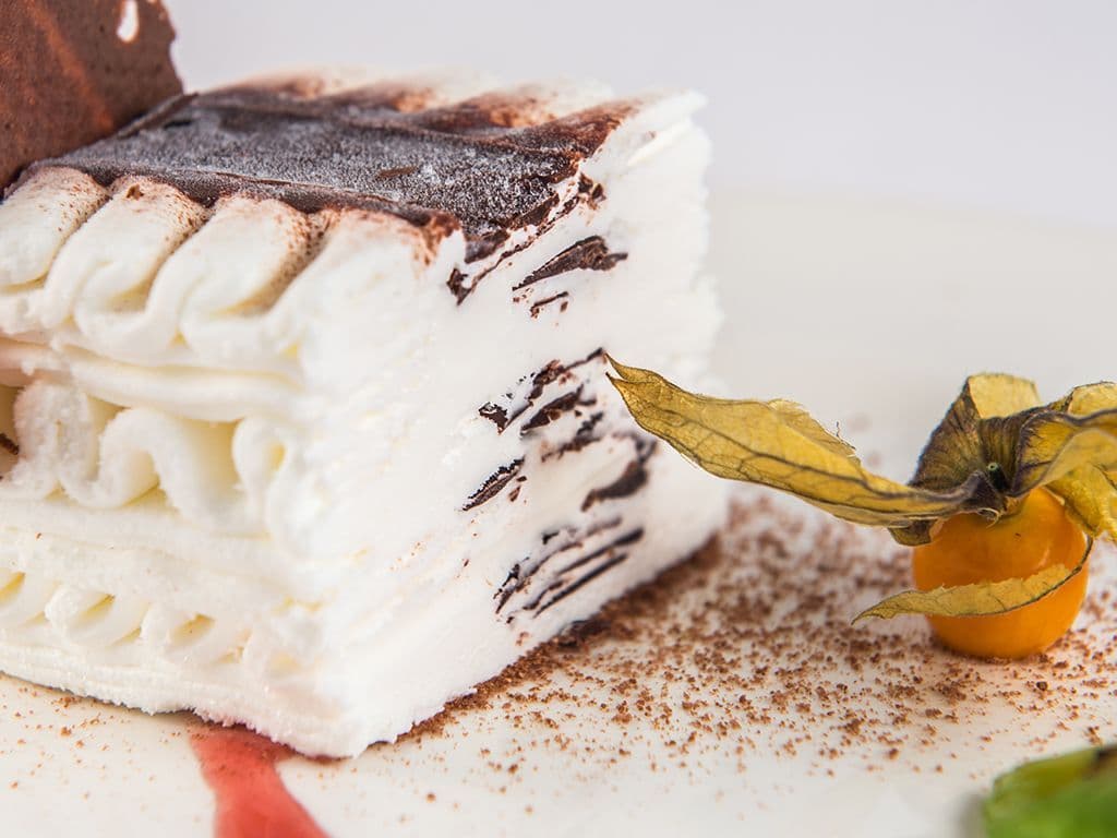 Welk klassiek dessert, dat bekend staat om zijn golvende lagen van roomijs en knapperige chocolade, werd in de jaren ’80 populair als luxe ijstaart voor feestelijke gelegenheden?