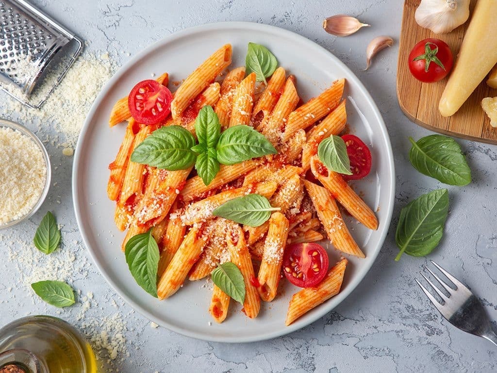 Voor de minder begaafde koks onder ons klinkt dit recept waarschijnlijk heel herkenbaar. Met ingrediënten zoals penne, tomaten, look, rode chilipeper, ui en Parmezaanse kaas, welk klassiek Italiaans gerecht zoeken we?
