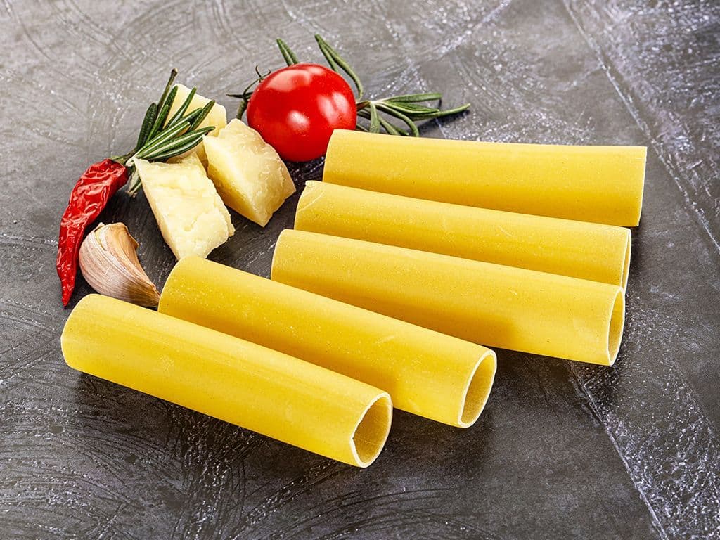 Welke klassieke Italiaanse pastasoort bestaat uit grote, holle pastabuizen, wordt gevuld met ingrediënten zoals gehakt, spinazie en ricotta, daarna overgoten met tomatensaus of bechamelsaus en in de oven gebakken tot een rijk en hartig gerecht dat vaak wordt geserveerd als comfortfood?