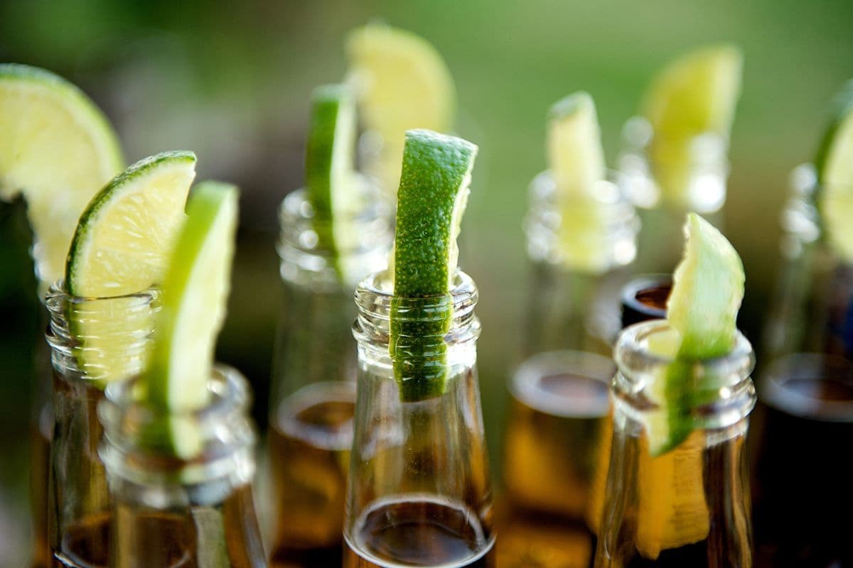 We verkopen het niet want dan zou het maar al te makkelijk zijn. De merknaam die we zoeken is een Mexicaans biermerk van brouwerij Grupo Modelo (eigendom van AB InBev). Het heeft een alcoholpercentage van 4,5% en heeft een lichte kleur. Door een beperkt gebruik van hop heeft het bier een neutrale smaak, iets wat in de Verenigde Staten, LatijnsAmerika, Canada en Europa wordt gecompenseerd door het te serveren met een stukje citroen of limoen in de flessenhals. Welk bier(merk) zoeken we?