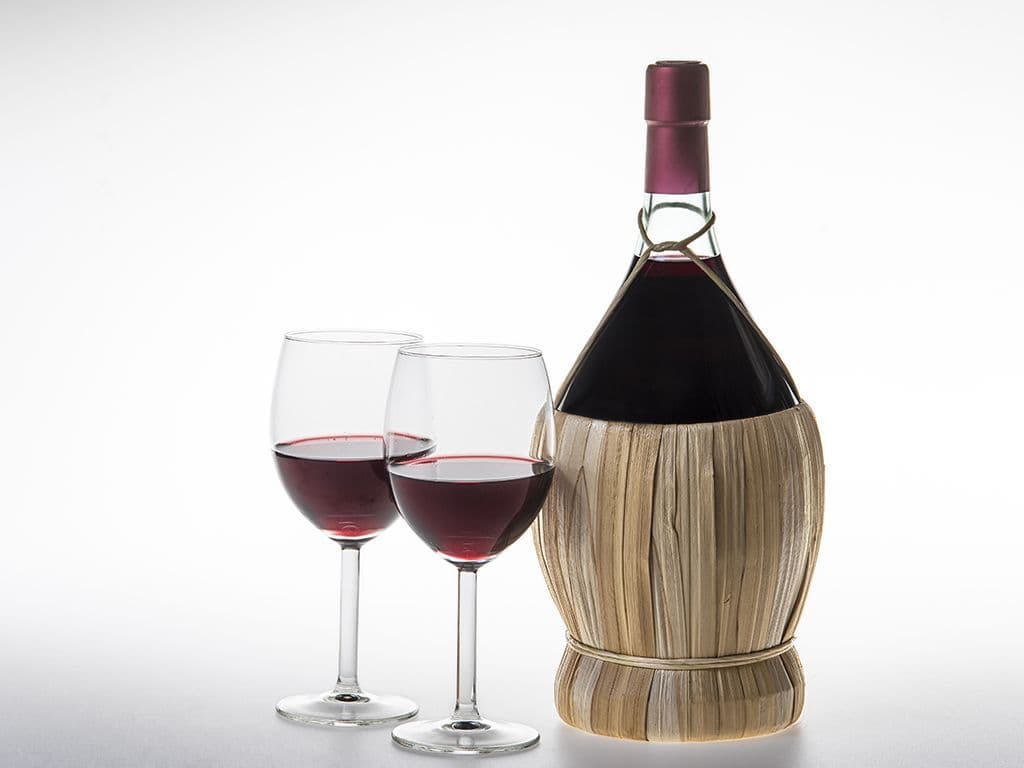 Hoe heet de traditionele Italiaanse mandfles voor wijn, omwikkeld met stro en oorspronkelijk ontwikkeld in de late middeleeuwen om flessen tegen breuk te beschermen, die vooral bekend werd door eenvoudige Chianti-wijnen maar tegenwoordig minder gebruikt wordt door de hoge kostprijs?