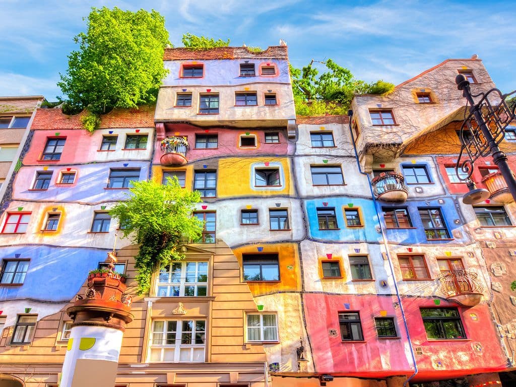 Naar welke Oostenrijkse kunstenaar en architect is het huis op de foto genoemd? Hij stond vooral bekend om de door hem ontworpen, kleurrijke gebouwen en was voorvechter van een mens- en milieuvriendelijke bouwwijze.