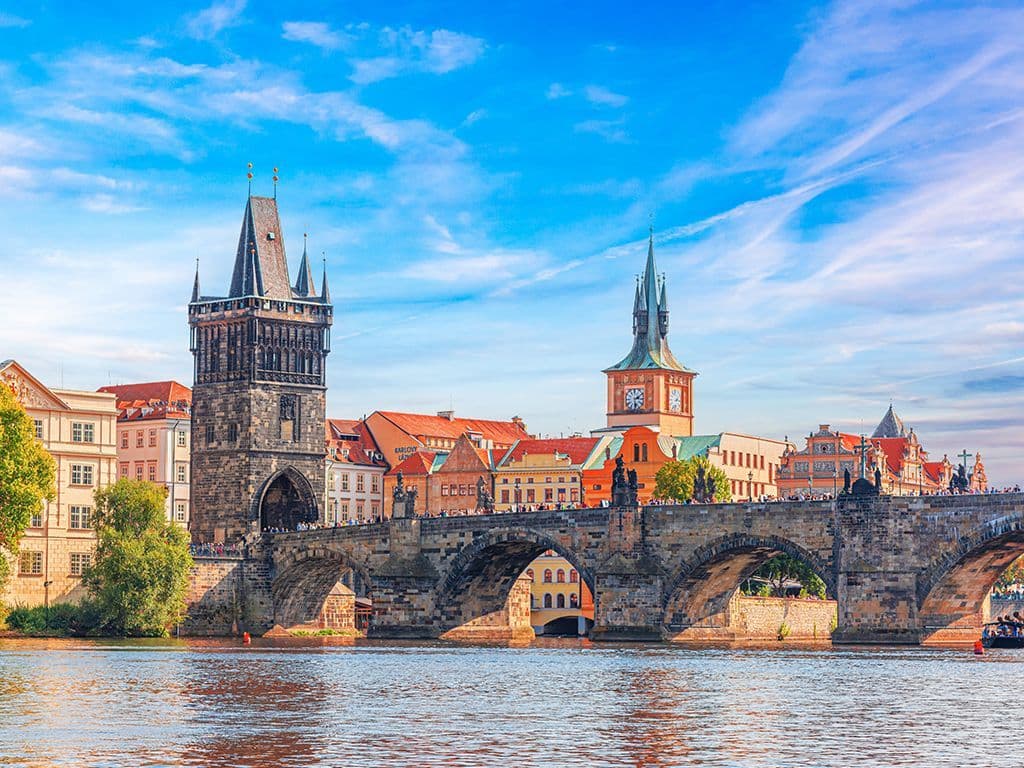 Een iconische middeleeuwse stenen brug in Praag, versierd met beelden van heiligen, die de Oude Stad met de wijk Malá Strana verbindt en een populaire toeristische attractie is.