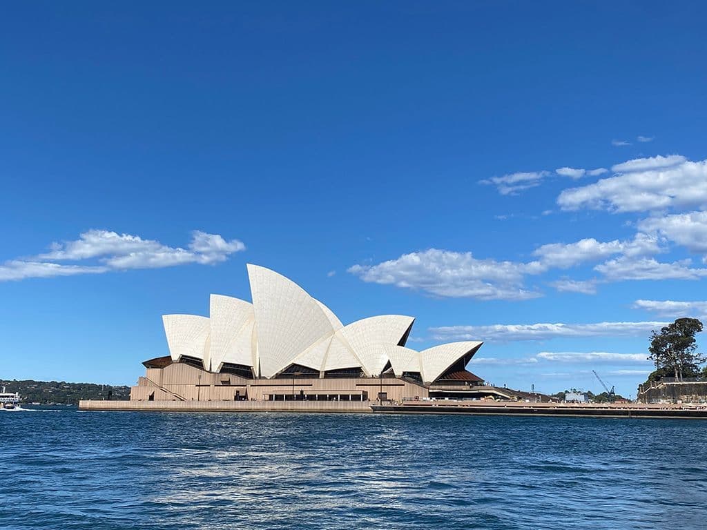 De eerste architect van wie een creatie tijdens zijn leven op de UNESCO-Werelderfgoedlijst belandde was Oscar Niemeyer, met zijn ontwerp voor Brasília. Maar wij zoeken nummer twee. Niet voor dit parlementsgebouw in Koeweit. Niet voor deze watertoren in zijn thuisland Denemarken. En evenmin voor Can Lis en Can Feliz, de huizen in Majorca waar hij de laatste jaren van zijn leven doorbracht. Maar wel voor dit gebouw. Wie is dus deze Deen die in 2003 de Pritzkerprijs voor Architectuur won?