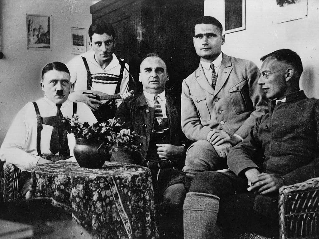 Een foute Fransman hebben we ook al gehad. Tijd voor een foute Duitser. Maar of de man zelf veel plezier heeft beleefd aan die hoedanigheid, valt te betwijfelen. De man mocht dan wel de plaatsvervanger van Hitler zijn, maar wat hem precies bezielde bij zijn solo-‘vredesmissie’ naar Schotland op 10 mei 1941, is nog altijd een goed bewaard geheim. Zijn wenkbrauwen benamen hem het zicht, zijn Messerschmitt landde ergens in een akker, de man brak zijn enkel bij de parachutesprong, werd door enkele locals overgeleverd aan het Britse leger en bracht de rest van de oorlog door in huisarrest, in een Engels landhuis. Alwaar hij twee zelfmoordpogingen ondernam en nog wat meer breuken opliep. Na de oorlog werd hij veroordeeld op het proces van Neurenberg en verbleef hij als laatste nazi in de Spandaugevangenis, waar zijn laatste zelfmoordpoging in 1987 de goeie bleek. Wie was er fout in de oorlog en nog een heel eind erna? Op de foto zie je hem als tweede van rechts.