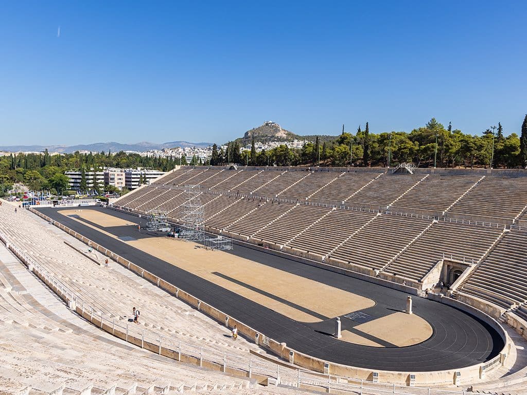 Elk jaar wordt de olympische vlam ontstoken in Griekenland en vervolgens doorgegeven om de aankomende Spelen in te luiden. Deze ceremonie vindt plaats in een iconisch stadion in Athene, dat bekend staat om zijn historische betekenis en prachtige architectuur. Weet jij de naam van dit stadion waar de ceremonie elk jaar plaatsvindt?
