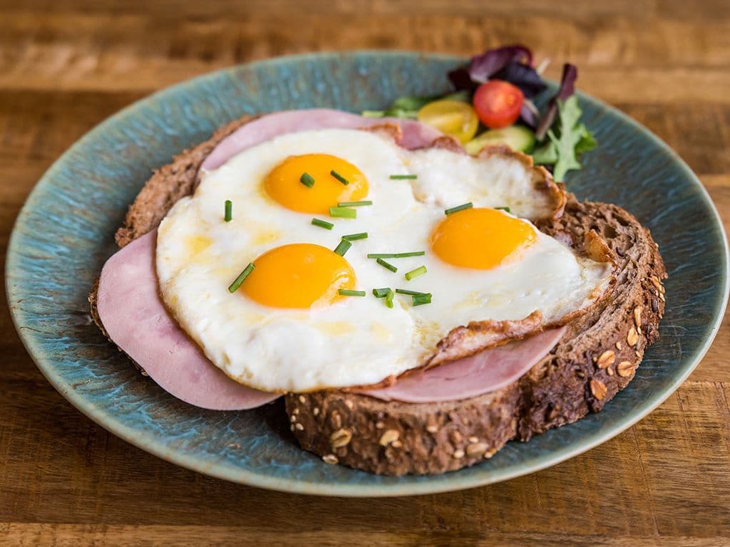 Het eiergerecht dat we zoeken komt voor op de meeste kleine kaarten van onze tavernes. Het bestaat meestal uit 2 sneden brood , enkele spiegeleieren, en ham en/of kaas. Buitenwippers werken dit met plezier naar binnen.